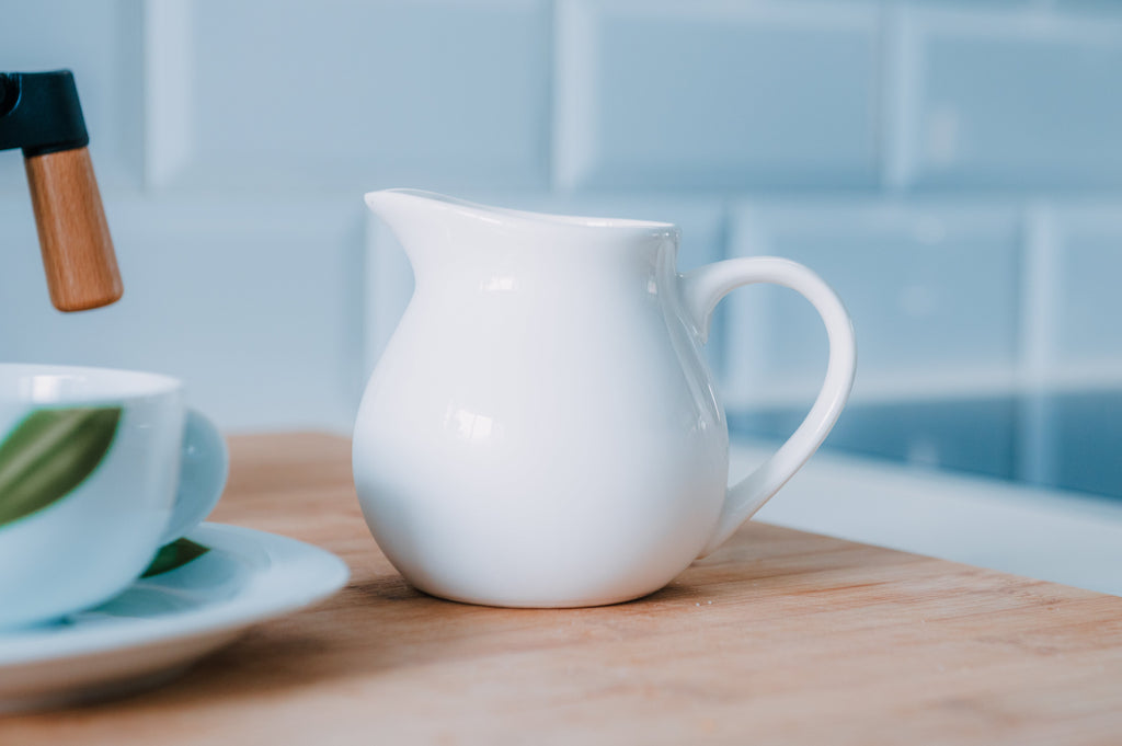 Jarra de leche de porcelana blanca