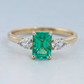 Emerald Gemstone And Pear Diamond Trio Engagement Ring