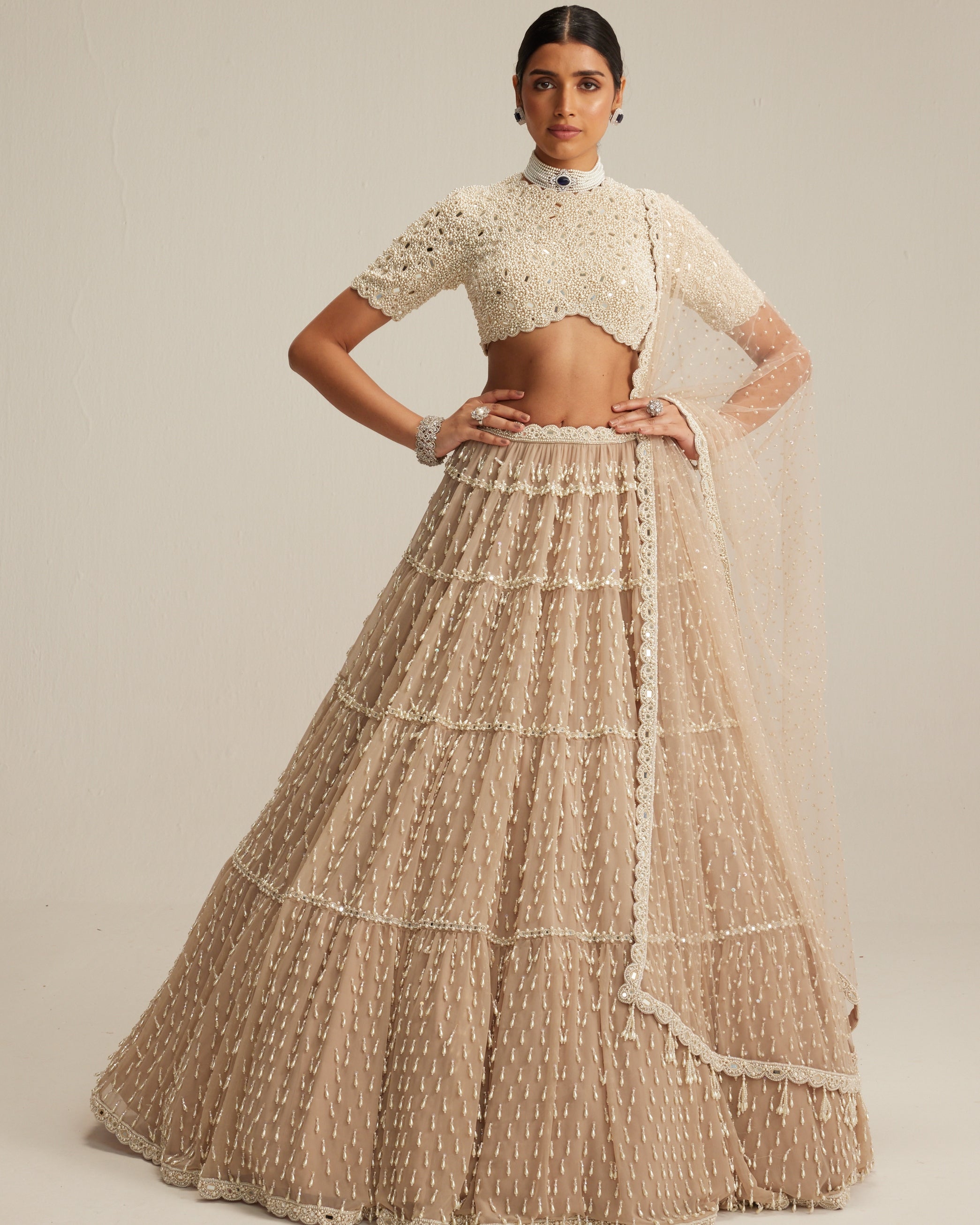 Light Beige Pearl Drop Multi Tier Lehenga With High Neck Blouse Set By KYNAH, Luxury Indian Fashion & Bridal Wear