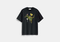 COACH® Unisex Camiseta De Corte Holgado 10º Aniversario De Rexy De Algodón Orgánico en Negro, Talla Mediano