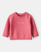 Sudadera rosa con mensaje “More Hugs Please”