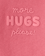 Sudadera rosa con mensaje “More Hugs Please”